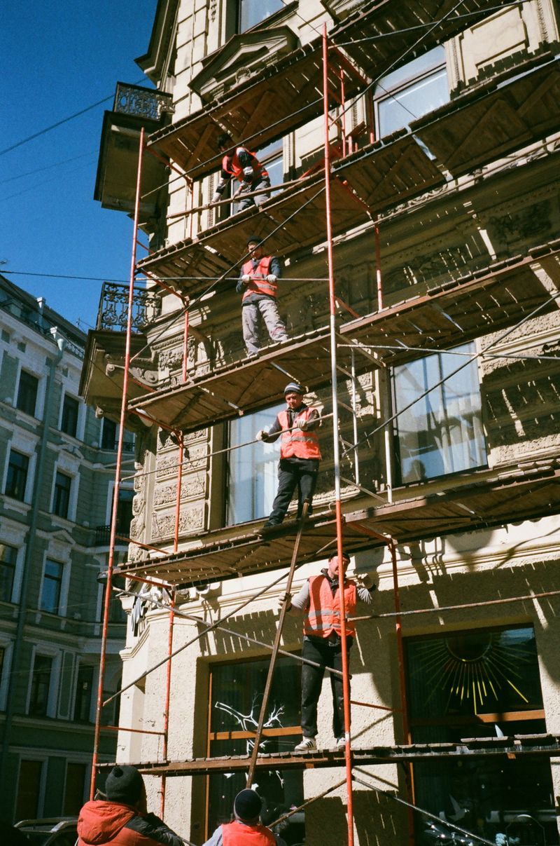Echipă pe schelă renovând fațada unei clădiri în Iași